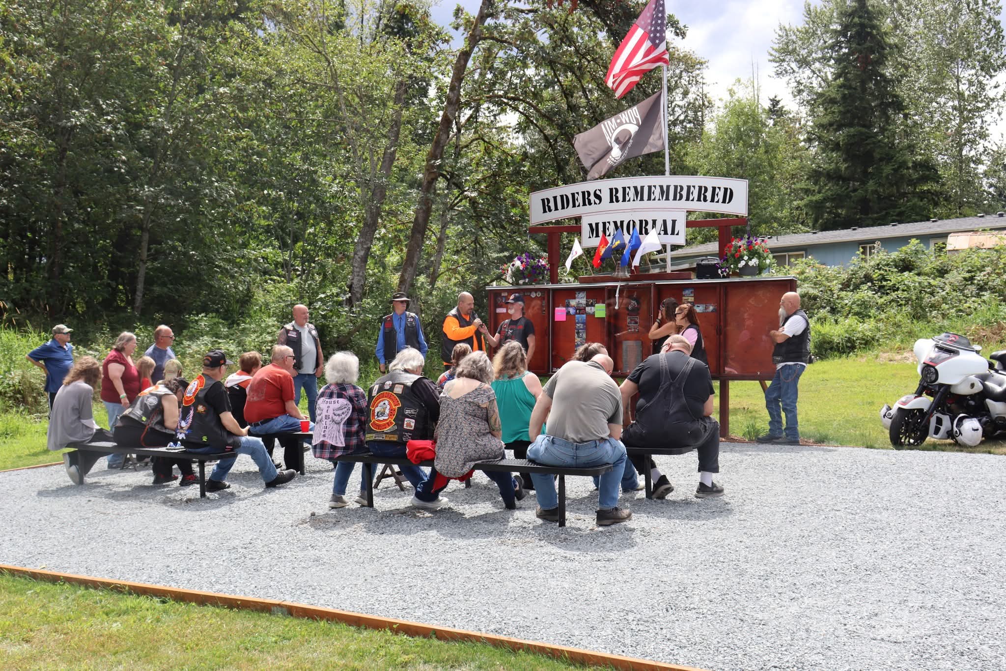 Riders and families gathered together in front of the Riders Remembered memorial