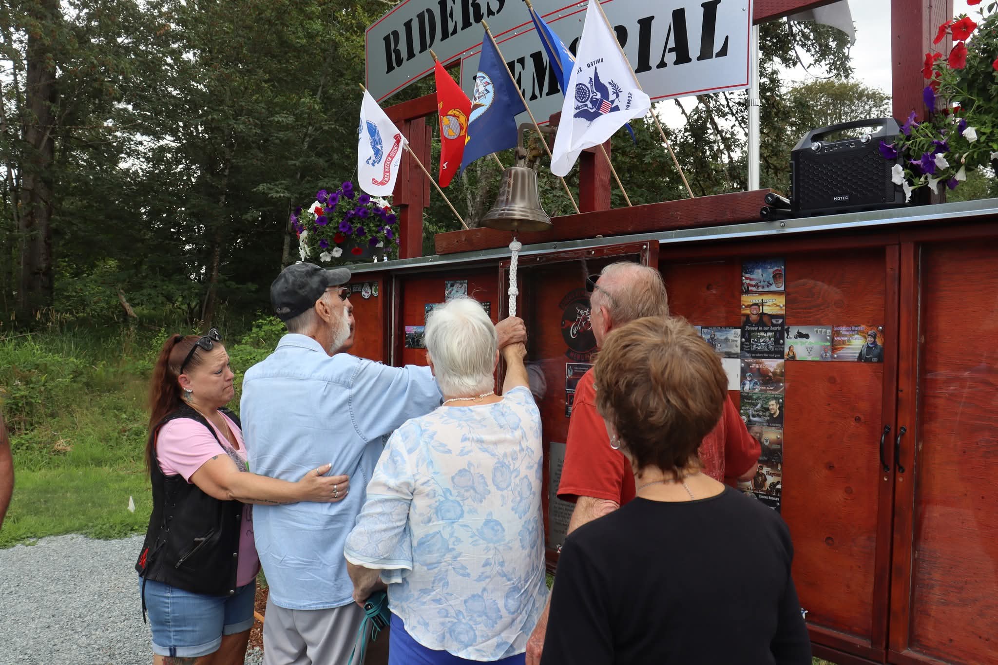 Friends standing together beside the completed memorial wall